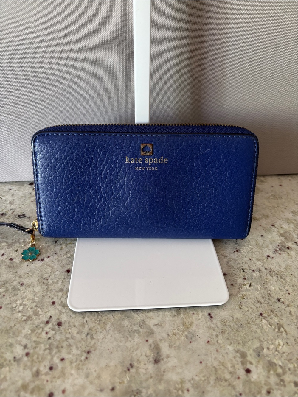 kate spade cobalt blue zip-around leather wallet with floral charm